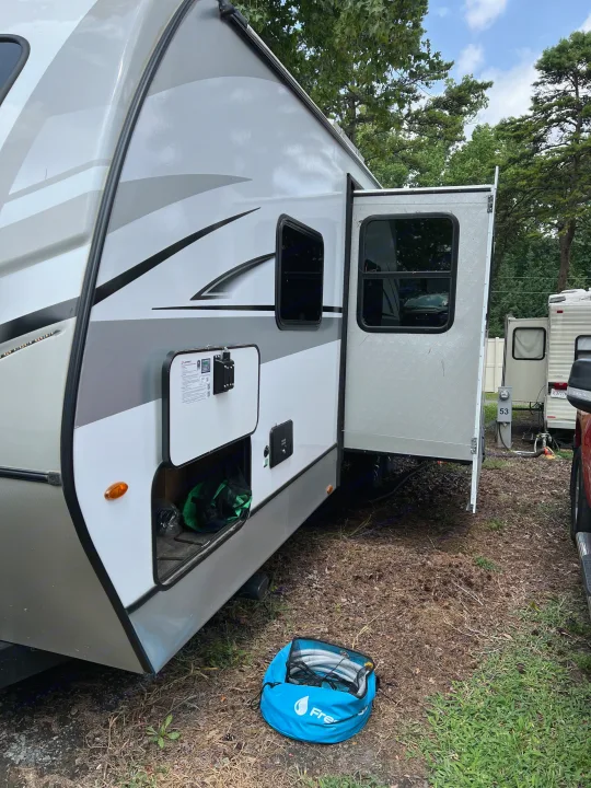 RV rental bedroom: cozy bed, ornate headboard, storage cabinets, and side shelves. Ready for your adventure.. Keystone RV Cougar 2023