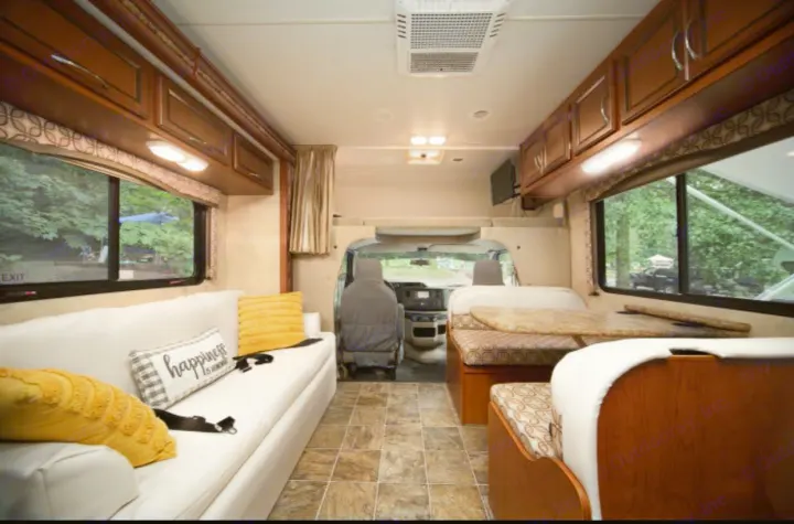 Spacious RV rental interior with a bright living area, featuring a comfy sofa, dinette, and ample storage for travel adventures.. Other Four Winds 2013