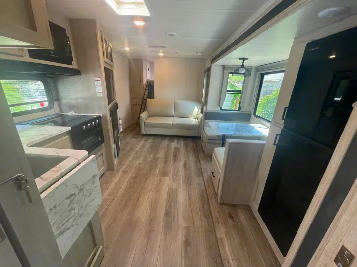 Spacious and modern RV rental interior featuring a full kitchen, comfortable living, and dining areas.. East to West Alta 2022