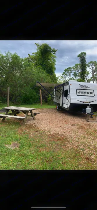 Cozy rv rental Jayco travel trailer at a shaded campsite with a picnic table, perfect for your next outdoor adventure.. Jayco Jay Flight 2018