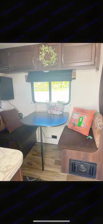 Comfortable RV rental interior: dinette, dark wood cabinets, TV, and scenic window. Ideal for road trips!. Jayco Jay Flight 2018