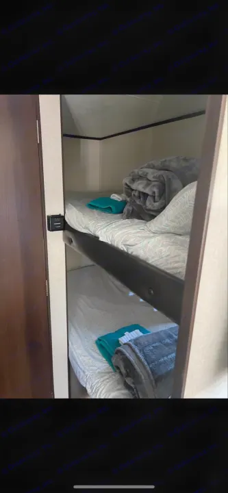 Inside an RV rental, two bunk beds with patterned sheets, blankets, and towels offer a cozy sleeping area.. Jayco Jay Flight 2018