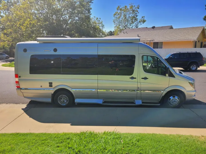 A silver Mercedes-Benz Sprinter camper van, ideal for an RV rental, parked on a sunny street.. Winnebago Era 2016