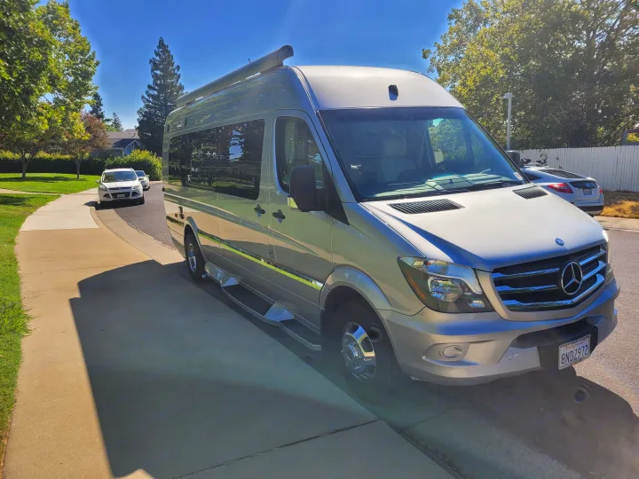 Silver Mercedes Sprinter RV rental on a sunny suburban street.. Winnebago Era 2016