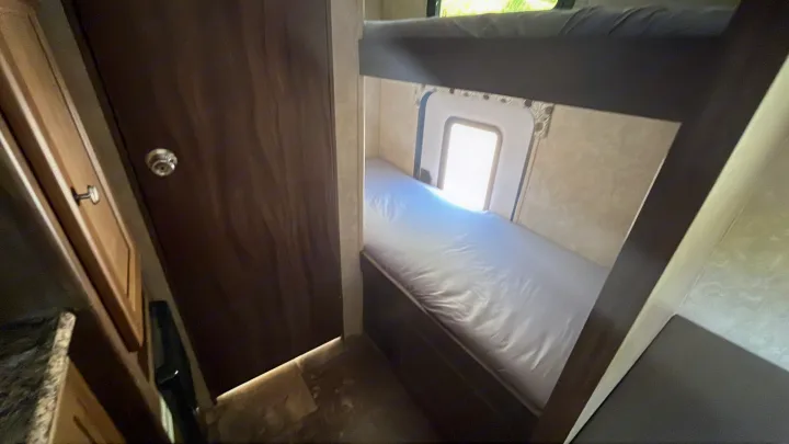 Cozy RV rental interior with bunk beds, a small window, and wood paneling. Perfect for travel and camping.. Clipper Clipper Trailer 2016