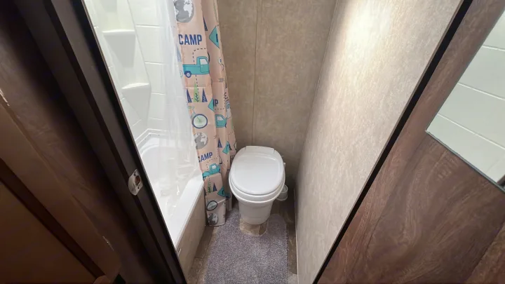 RV rental bathroom: compact shower, toilet, and fun camping curtain with trucks and globes.. Clipper Clipper Trailer 2016