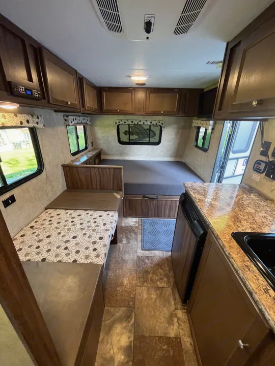 Cozy RV rental interior: A compact space with a rear bed, dinette seating, and a kitchen area with countertop.. Clipper Clipper Trailer 2016