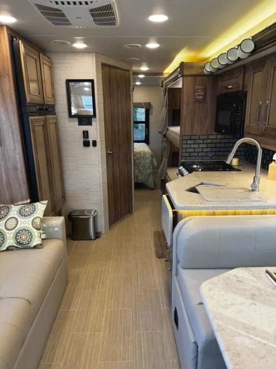 Spacious RV rental interior: modern kitchen, cozy living area, bunks, and bedroom access for your travels.. Jayco Greyhawk 2021