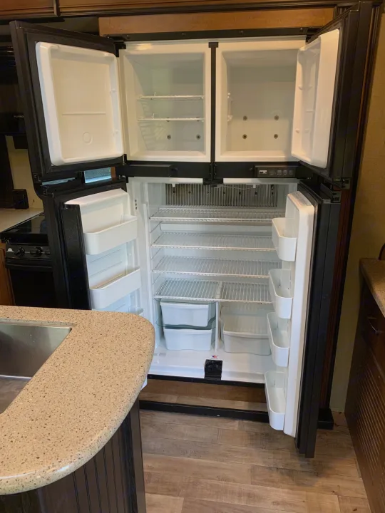 An RV rental's spacious, open refrigerator & freezer, ready for your journey's provisions.. Reflection BHT33 2018