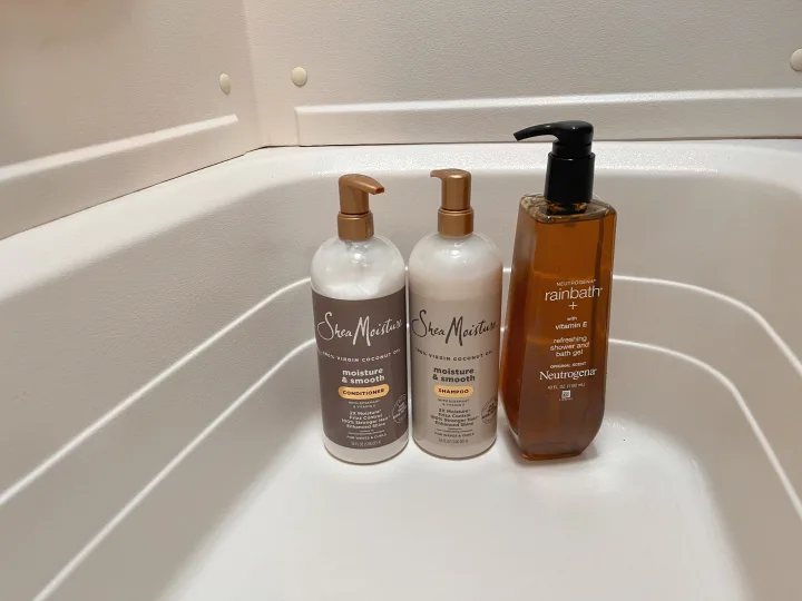 Shower essentials for an RV rental: Shea Moisture shampoo & conditioner, and Neutrogena Rainbath, in a textured stall.. Keystone RV Hideout 2017