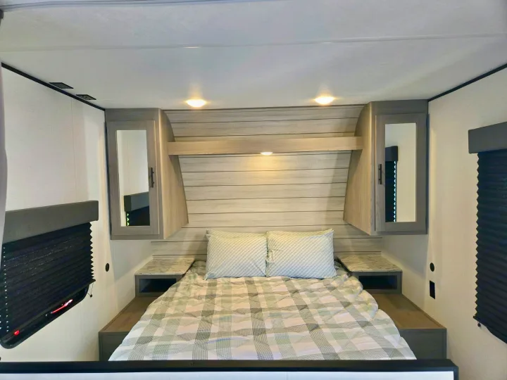 Experience comfort in this RV rental's bedroom. Features a cozy bed, mirrored cabinets, and wall-mounted shades.. Coleman Coleman lantern lt 2024