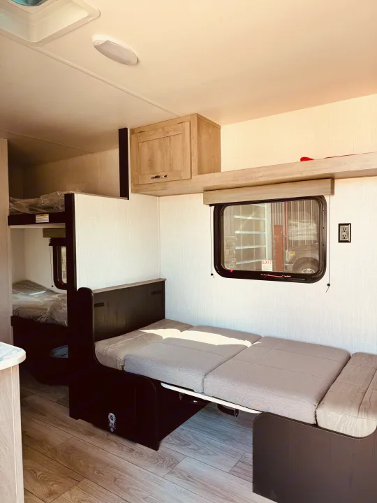 Clean RV rental interior showing a convertible dinette and bunk beds, offering compact living and sleeping space.. Cruiser RV Avenir 2024
