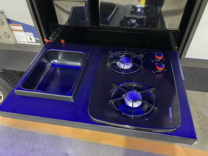 Experience outdoor cooking with this RV rental's pull-out kitchen: sink, 2-burner Suburban stove, propane ready.. Forest River Alpha Wolf 2022