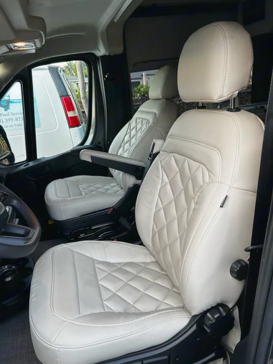 Experience comfort in this RV rental's interior: plush white quilted front seats, perfect for road trips and travel.. Thor Tellaro 2024