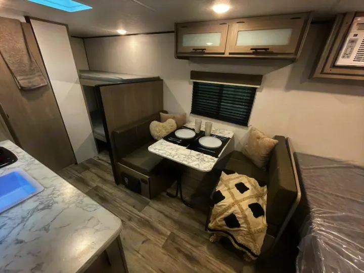 Spacious RV rental interior with a kitchen, dining area, and bunk beds, offering comfort for your adventures.. Coleman lantern lt 17b 2024