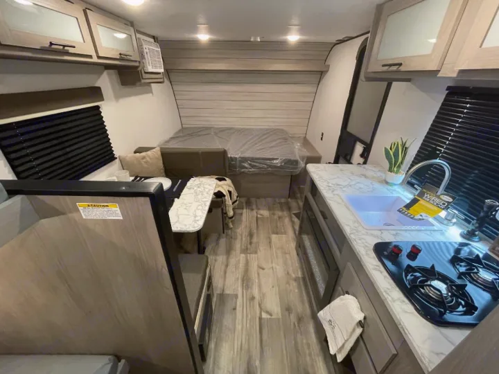 Step inside this RV rental! The cozy interior offers a full kitchen with sink/stove, convertible dinette/bed, and rear sleeping area.. Coleman lantern lt 17b 2024