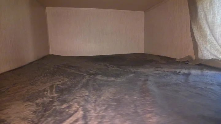 Cozy RV rental interior: A snug bunk bed with a dark grey blanket and light fabric walls, ready for sleep.. Palomino Solaire 2022