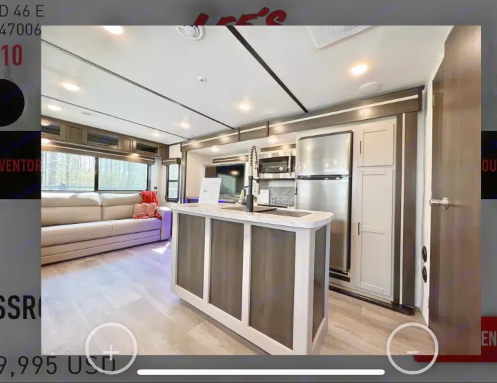 Spacious modern RV rental interior featuring a kitchen island, sofa, refrigerator, and microwave in a bright living area.. Crossroads RV Cruiser Aire 2022
