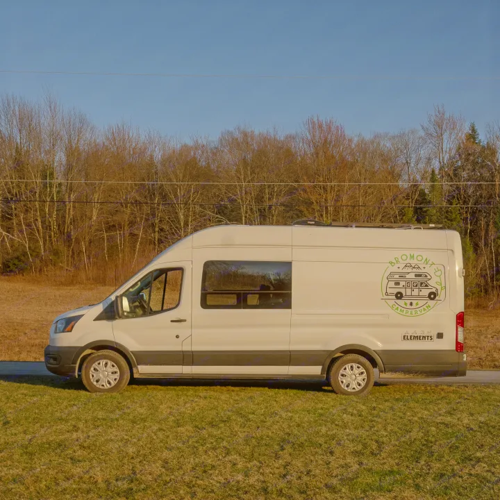 White Bromonto campervan rv rental, parked by a grassy field and forest under a clear blue sky, ready for adventure.. Ford Van 2023