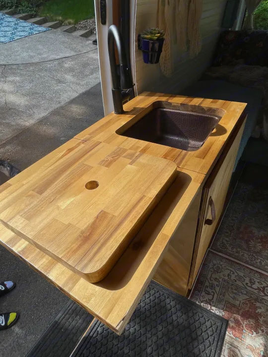 This RV rental camper van features a modern wood kitchenette with hammered copper sink, black faucet, & ample storage.. Ford Transit 2019
