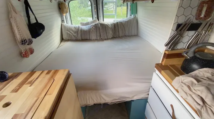Inside a well-organized rv rental campervan: large bed, smart storage, and a compact kitchen. Ready for travel!. Ford Transit 2019