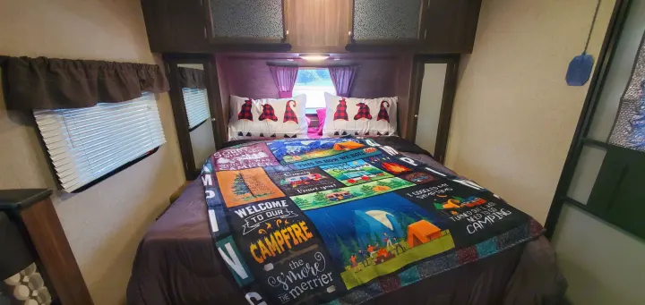 Cozy RV rental bedroom with a fun camping blanket & gnome pillows. Perfect for your next adventure!. Coachmen Apex Nano 2018