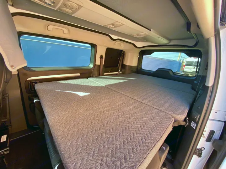 Spacious camper van rv rental interior with a comfortable, flat bed setup, perfect for your next travel adventure.. Adria Mode 2024