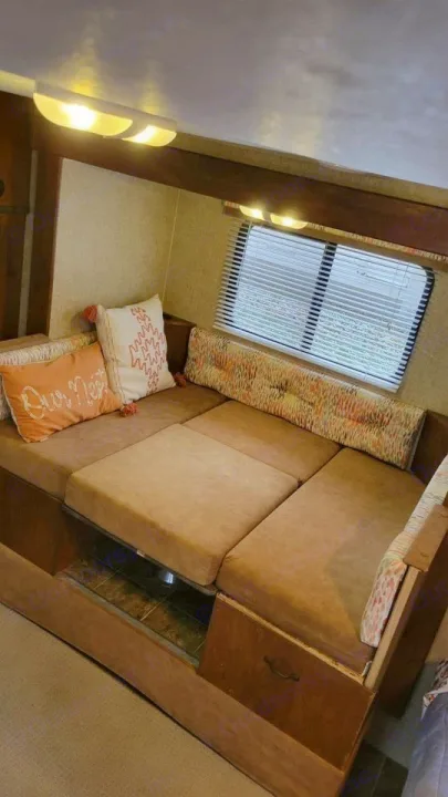 Cozy RV rental living space with bright overhead lights and a versatile convertible sofa bed.. Spree Escape 2016