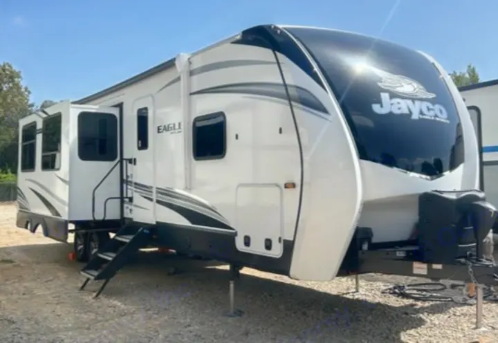 Experience comfort with this white Jayco Eagle fifth-wheel RV rental, featuring an open door and extended steps, ready for adventure.. Jayco Eagle 312 BHOK 2024