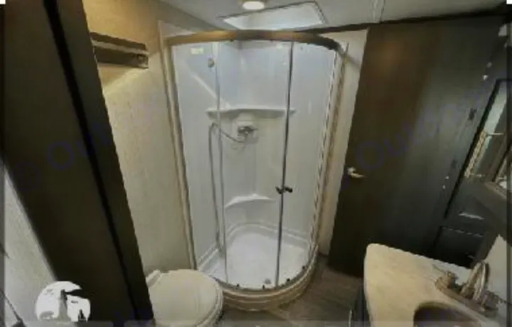 This RV rental features a compact, functional bathroom with a corner shower, toilet, and sink vanity.. Keystone Cougar 2021