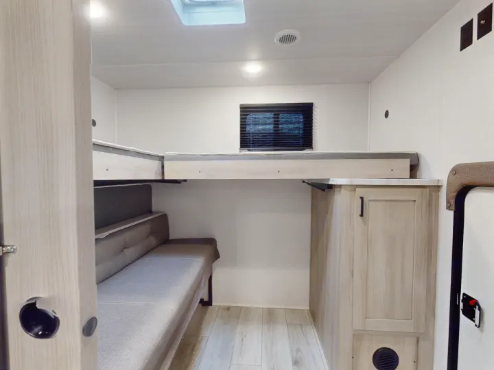 This RV rental offers a versatile interior with a convertible sofa and comfortable bunk beds, perfect for family travel.. East to West Silver Lake 3250QB 2025