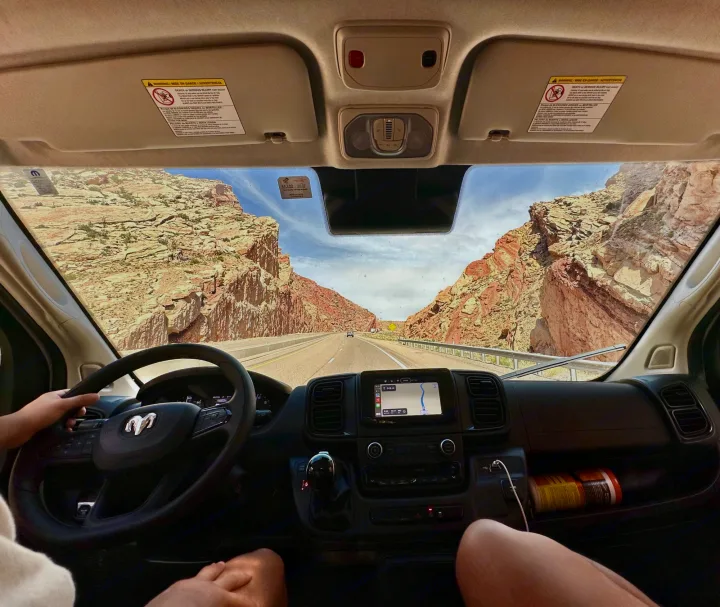 Road trip adventure in an RV rental, navigating breathtaking red rock canyons. Driver's view of highway and navigation display.. RAM PROMASTER 2500 2023