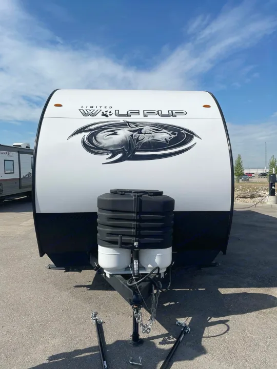 Front of a white Wolf Pup travel trailer with propane tanks, ready for your next RV rental adventure.. Forest River Cherokee Wolf Pup 2023