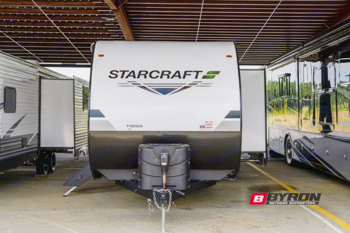 Front view of a white Starcraft travel trailer with black diamond plate, suitable for RV rental, at an outdoor superstore.. Starcraft Autumn Ridge 2023