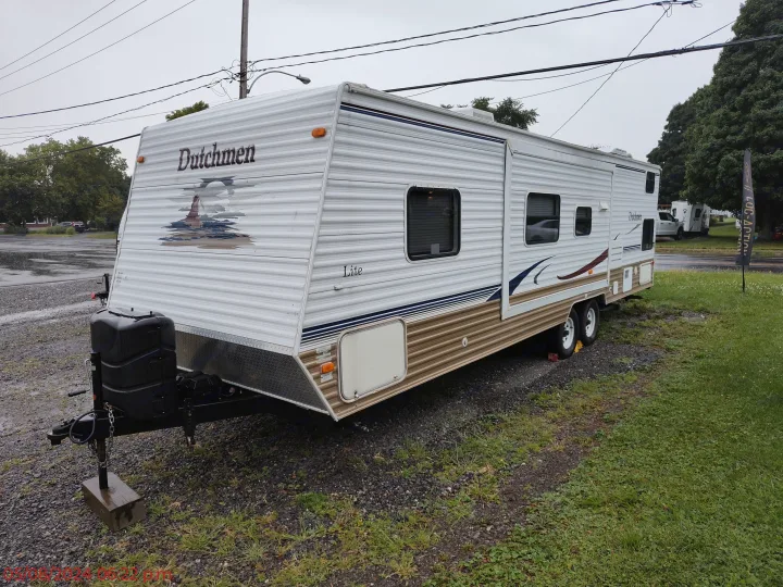 White Dutchmen Lite travel trailer RV rental, parked on gravel.. Dutchmen Dutchmen 2007