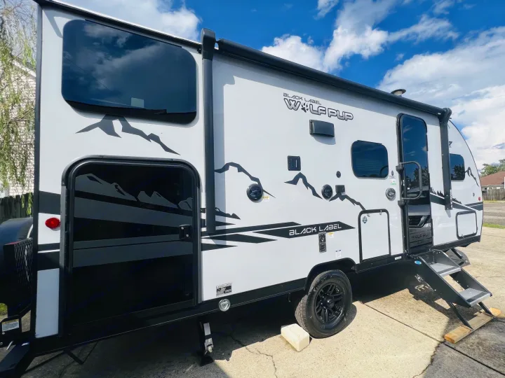 Get ready for adventure in this white & black travel trailer, featuring mountain graphics & dual open doors. Ideal for RV rental trips.. Forest River Cherokee Wolf Pup Black Label 2022