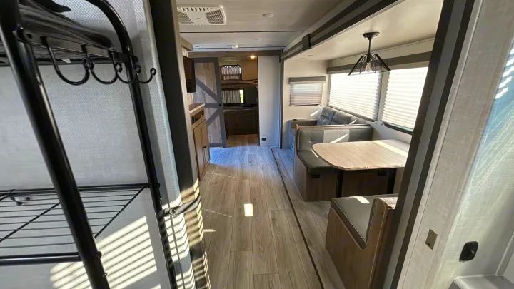 Spacious RV rental interior with dinette, couch, and bunk beds. Modern design for comfortable travel.. Forest River Surveyor Legend 2023
