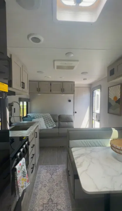 Spacious RV rental interior: Modern kitchen, comfy sofa, and bright dinette area. Ready for your next travel adventure.. East to West Silver Lake 2023