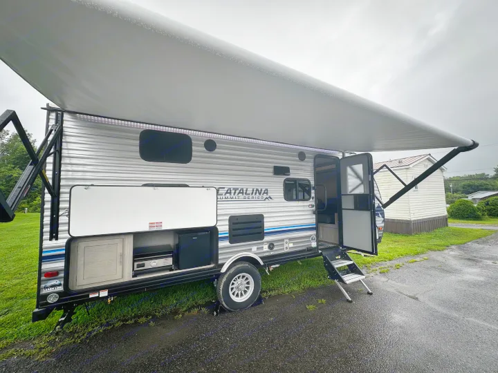 This RV rental is set up with its extended awning and outdoor kitchen, perfect for a cozy rainy day.. Coachmen Catalina 2022