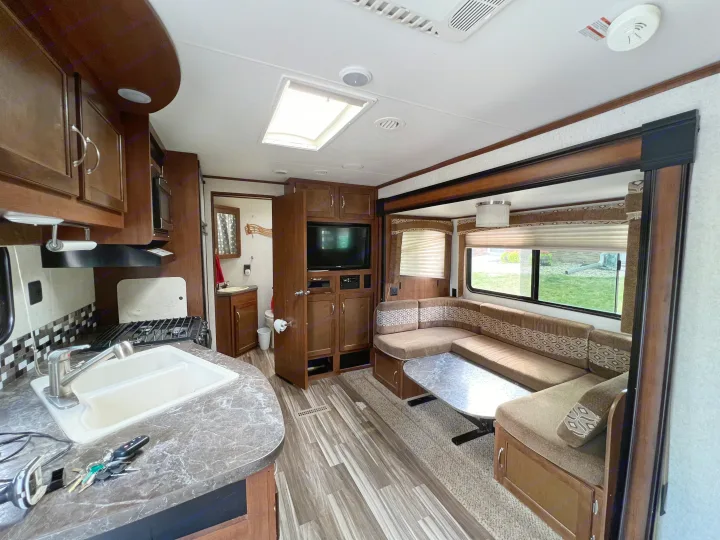 RV rental interior with kitchen, U-shaped dinette, entertainment area, and bathroom access.. Jayco Jay Flight 2014