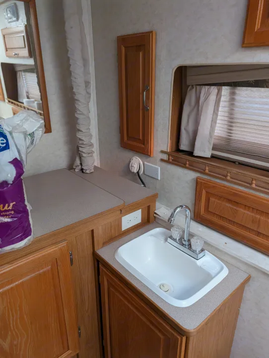 RV rental: view of a compact kitchenette with a white sink, wood cabinets, and a window with blinds.. Hi Lo 2307c 2007