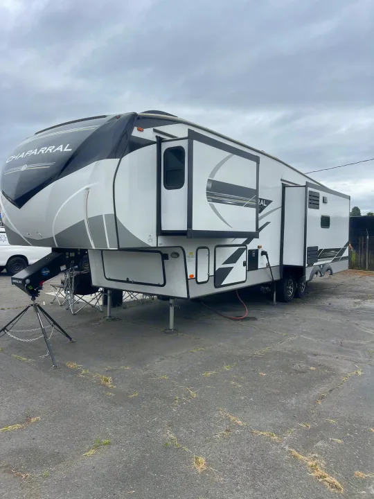White and black Chaparral Fifth Wheel RV, fully extended and ready for your next outdoor rv rental adventure.. Coachmen Chapparal 336 TSIK 2022