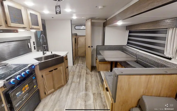 Modern rv rental interior with full kitchen, dinette, and bunk beds visible through the doorway.. Forest River Cherokee Grey Wolf 2022