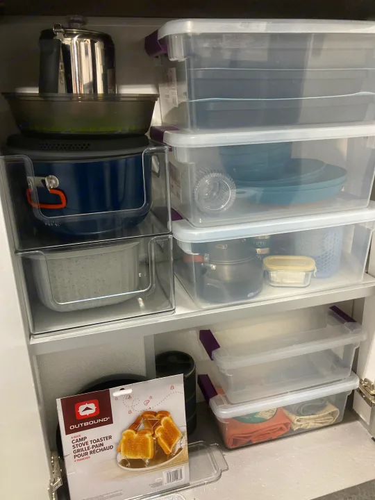 RV rental kitchen gear: Organized camping pots, dishes, & an Outbound toaster in clear storage bins.. Helio Helio Trailer 2023