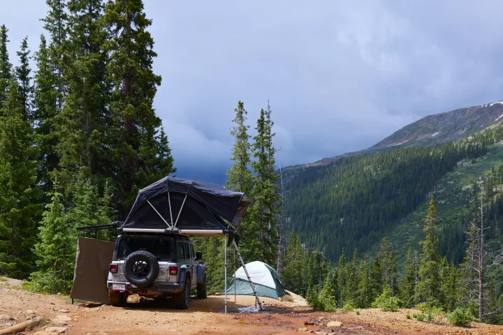 Overland camping setup with rooftop tent & ground tent, a great RV rental alternative in the mountains.. Jeep Wrangler 2024