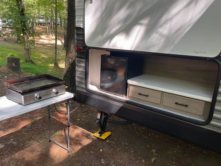 Camping made easy with this RV rental's outdoor kitchen, featuring a griddle, mini-fridge, and storage drawers.. Jayco JayFlight SLX 2024