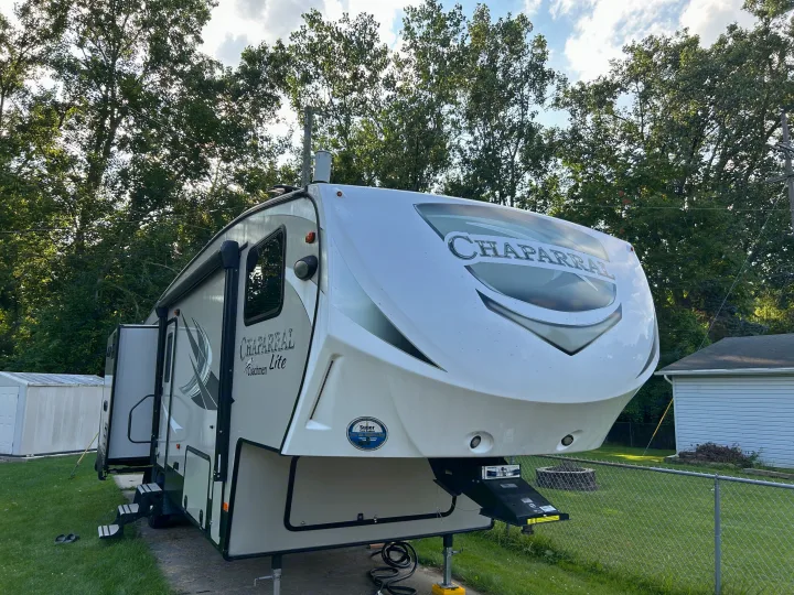 A large white Chaparral fifth-wheel RV, ready for your next rv rental camping trip.. Forest River Coachmen Chaparral Lite 2019