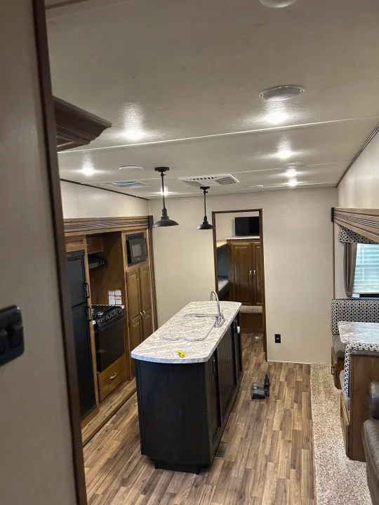 Spacious RV rental interior featuring a modern kitchen island, full appliances, and a cozy dinette area.. Forest River Coachmen Chaparral Lite 2019