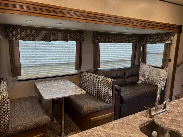 Spacious RV rental interior with a comfortable dinette, leather sofa, and kitchen area. Modern design for comfortable travel.. Forest River Coachmen Chaparral Lite 2019