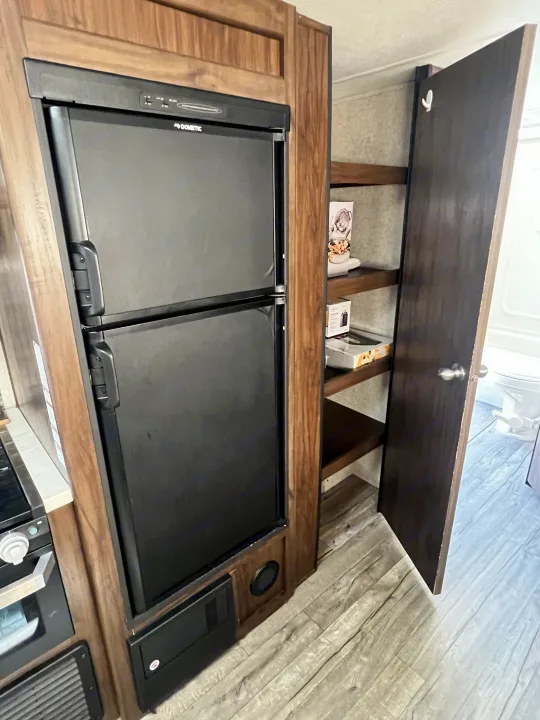 RV rental: Dometic fridge, pantry with shelves, and wood-look flooring. Practical kitchen setup for your travels.. Forest River Cherokee Grey Wolf 2019